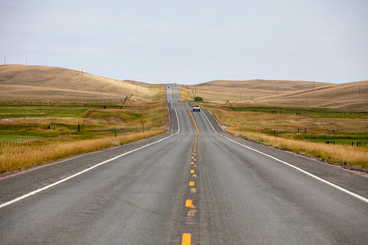 photo is of a long road ahead, with the yellow line in the middle of the frame.