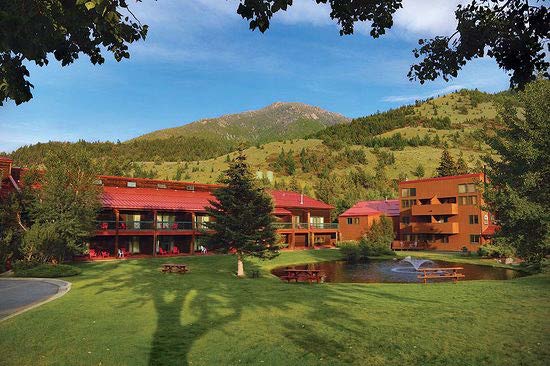 photo of a guest lodge against a green hillside in Red Lodge, MT.