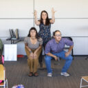 three performers in the front of a room photographed during a performance in a public library.